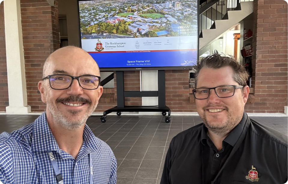 two men standing in front of a television